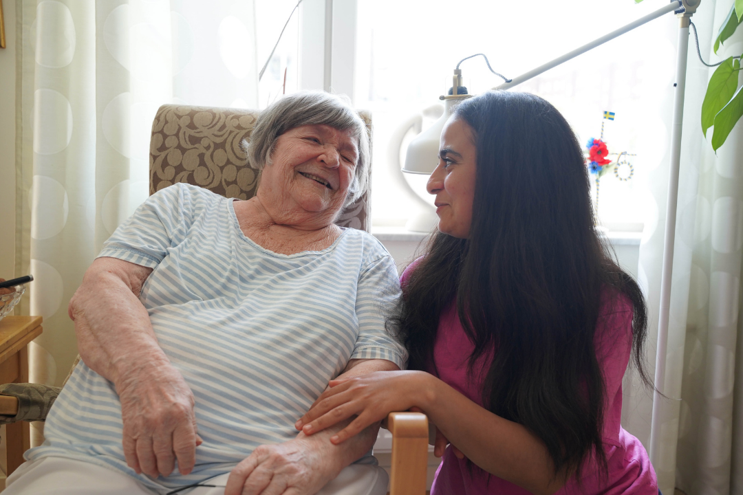 Jossa, som är hemtjänstkund, ler mot hemtjänstpersonalen från Attendo