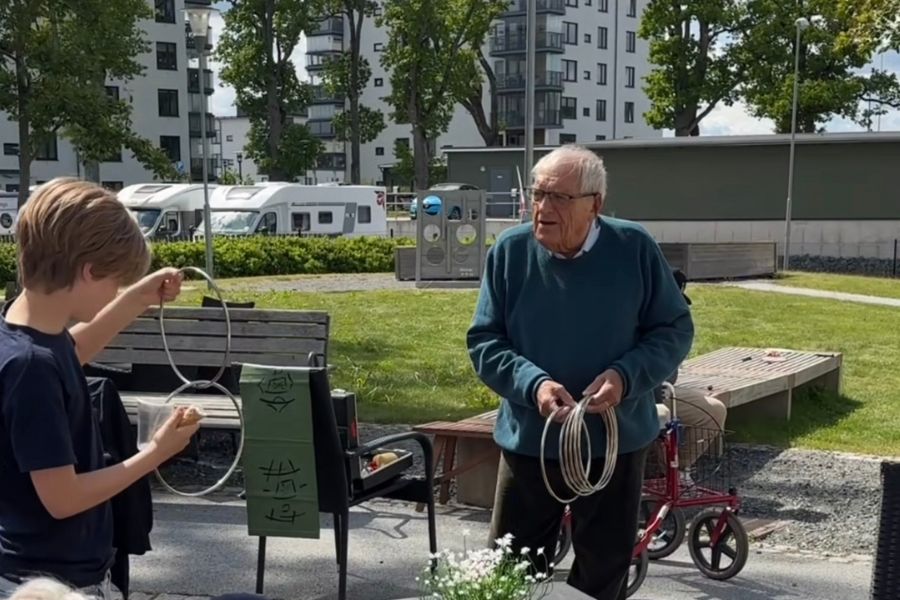 &Auml;ldre man trollar med ringar framf&ouml;r en av eleverna